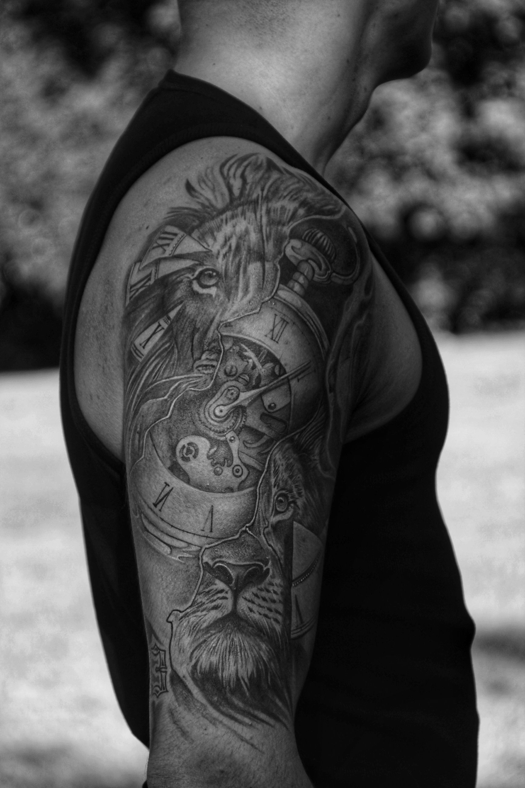 Sleeve de leão e relógio em preto e cinza no braço